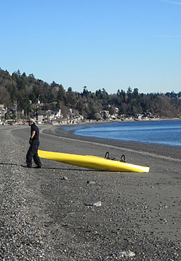 man with canoe on beach